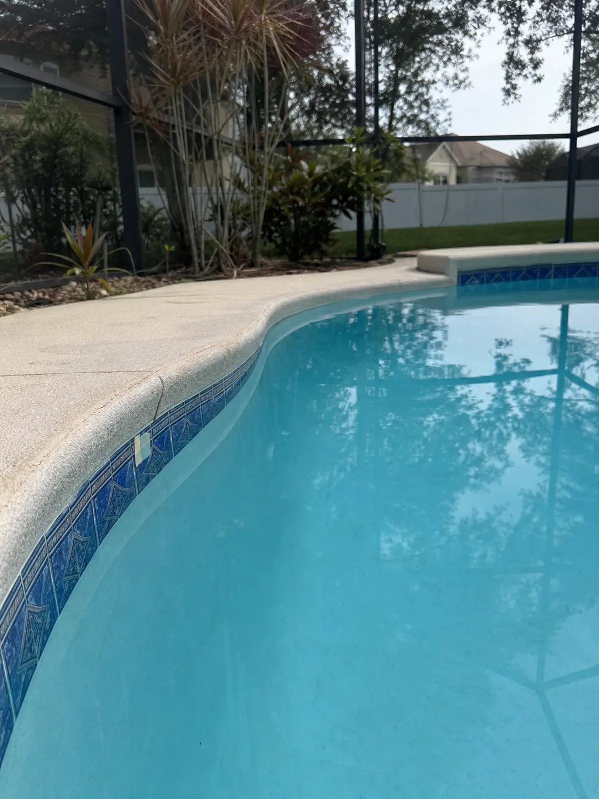 Tape marking the water level on pool tile to measure daily water loss during a leak test