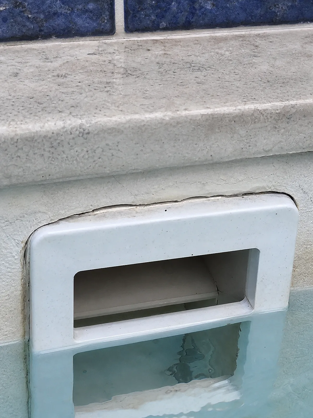 Fine crack at a pool skimmer throat where it meets the shell, a common Central Florida leak point
